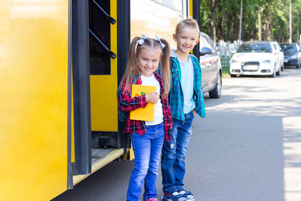 happy schoolchildren with backpacks get off the school bus. - Φωτογραφία, εικόνα