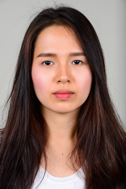 Studio shot of young beautiful Asian teenage girl against white background - Fotografie, Obrázek