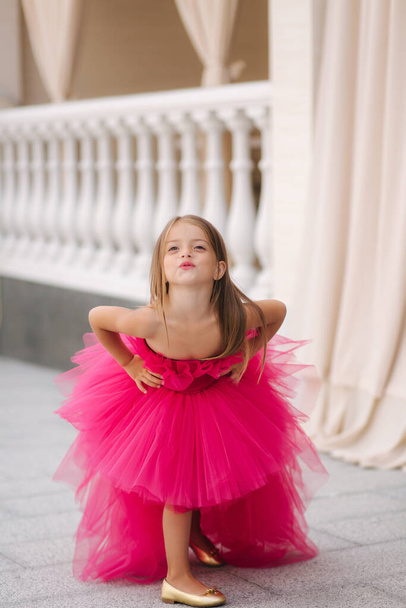 Krásná holčička v růžové načechrané šaty dát vzdušný polibek - Fotografie, Obrázek