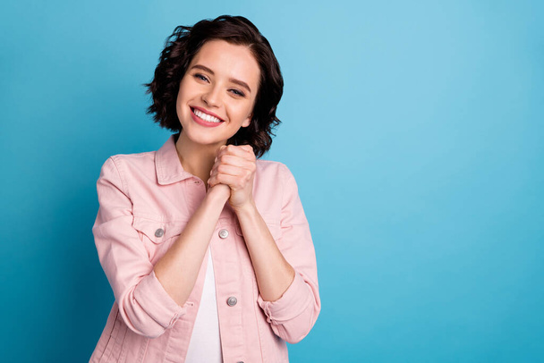 Photo of beautiful adorable lady short black hairdo hold arms together enjoy family surprise affectionate feelings wear casual pink jacket isolated blue color background - Foto, immagini