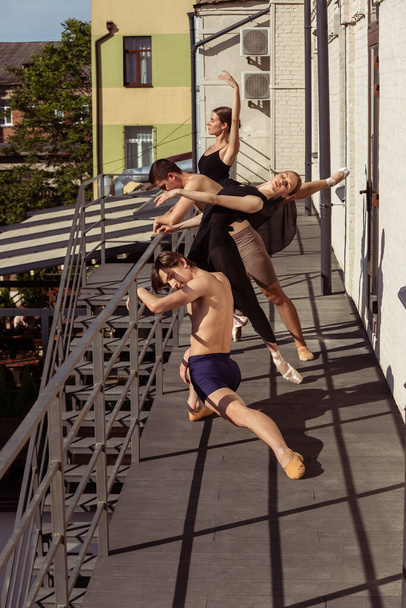 The group of modern ballet dancers performing on the stairs at the city - Photo, Image