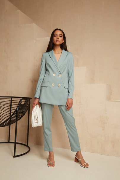 Beautiful brunette woman natural make up wear fashion clothes casual dress code office style blue jacket and pants suit for romantic date business meeting accessory bag interior boho stairs . - Foto, Bild