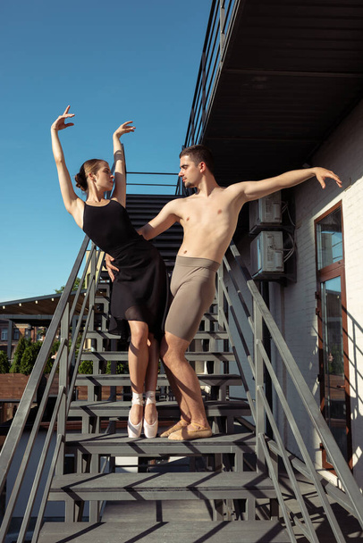 Couple of modern ballet dancers performing on the stairs at the city - Fotoğraf, Görsel