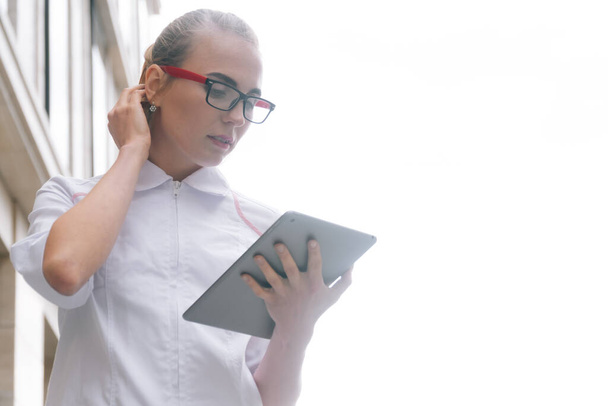 Beyaz cüppeli bir kadın doktor dijital tablet kullanan bir hastayla çevrimiçi istişarede bulunuyor. İş arkadaşlarıyla video görüşmesi konsepti - Fotoğraf, Görsel