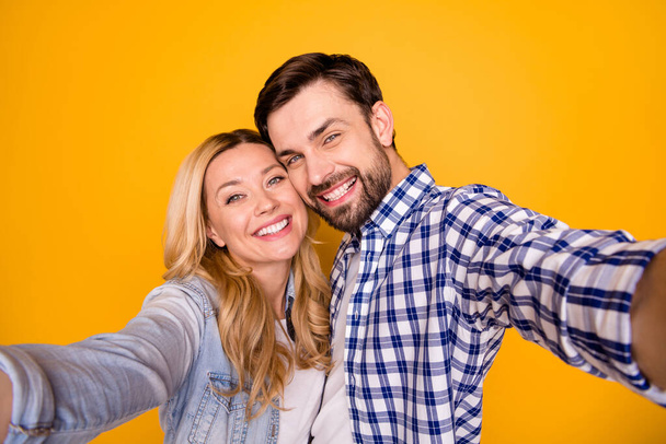 Closeup photo of pretty blond overjoyed lady handsome brunet guy couple spend quarantine together making selfies bloggers wear casual shirts isolated yellow color background - Фото, изображение