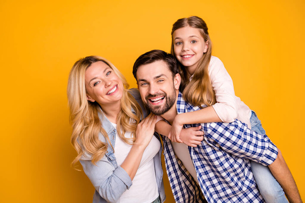 Photo wife beautiful mother lady husband dad guy couple carry little school girl daughter piggyback happy together play weekend wear casual clothes isolated yellow color background - Foto, immagini