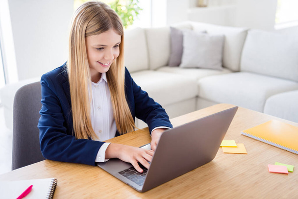 Photo of little pretty blond pupil school girl diligent student notebook online lesson web camera call sit distance quarantine study september home room house classroom indoors - Foto, Imagen