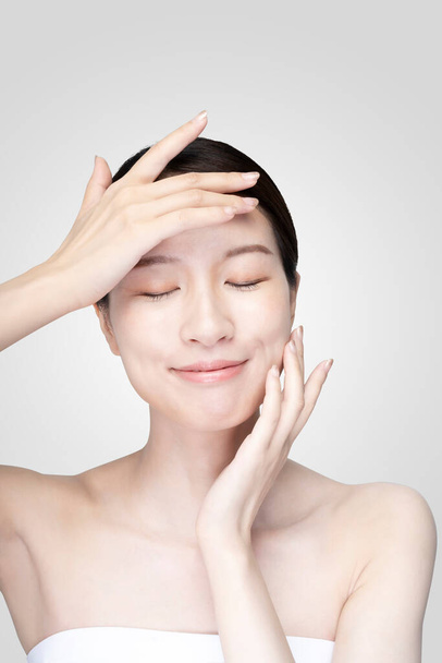 Asian young woman touching face with her hand in relaxed expression - Photo, Image