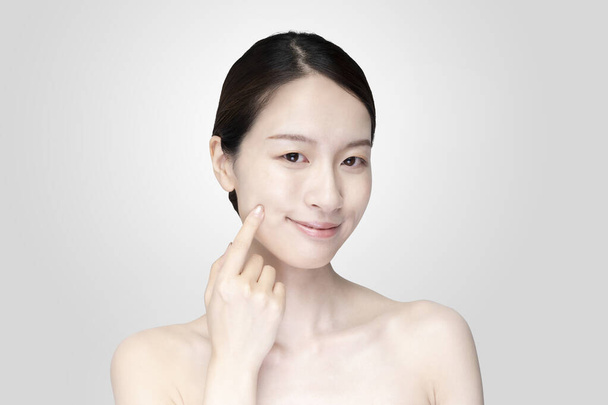 Asian young woman touching face with her hand in relaxed expression - Photo, Image