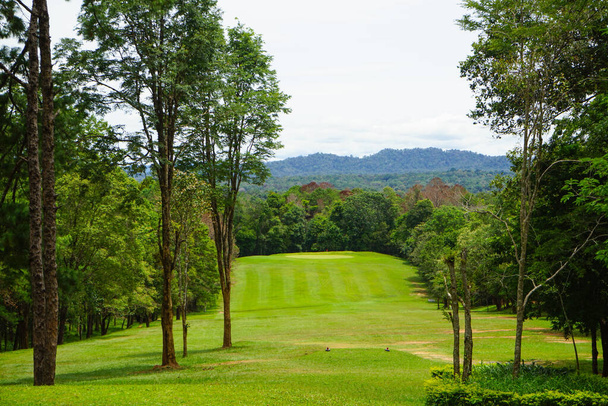 Background of evening golf course has sunlight shining down at golf course in Thailand. Nice scenery on a golf course at a late summer afternoon.                                - Photo, image