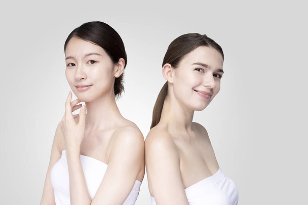 Mujeres jóvenes caucásicas y asiáticas se alinean vistiendo camisetas blancas sin hombro
 - Foto, imagen