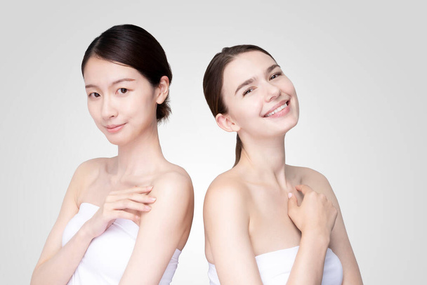 Valkoihoiset ja aasialaiset nuoret naiset riviin yllään valkoinen off-olkapää topit - Valokuva, kuva