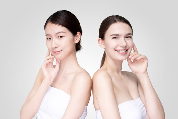 Caucasiens et asiatiques jeunes femmes aligner portant blanc off-shoulder tops - Photo, image