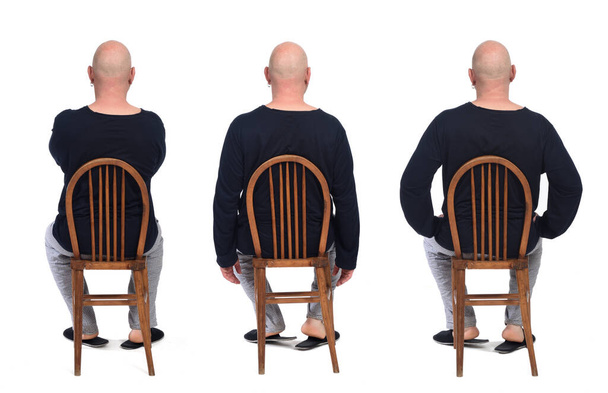 gruppo di stesso uomo in pigiama seduto o una sedia su sfondo bianco, vista posteriore - Foto, immagini
