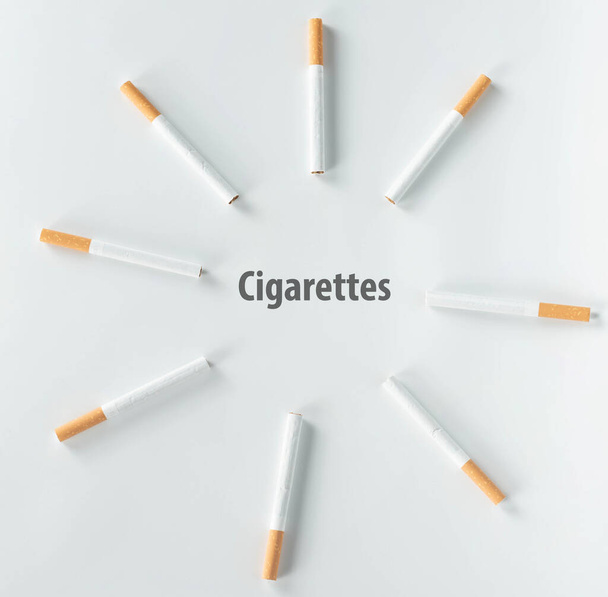 circle of cigarettes on white background from top view. - Fotoğraf, Görsel
