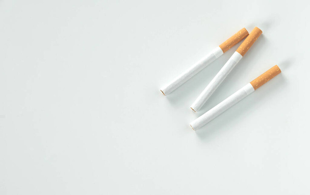 tři cigarety ležely na bílém pozadí pro koncept cancer.illness.from shora pohled s kopírovacím prostorem - Fotografie, Obrázek