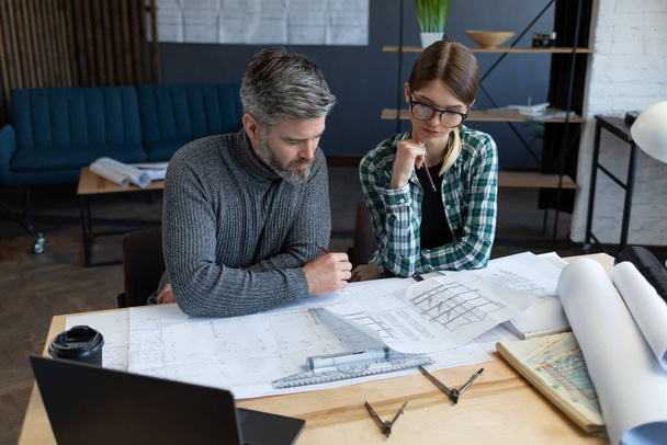 Interior designers team working in office with blueprints and architect equipment, sketching, negotiating and planning construction project. Partners discussing at work. Business construction concept - Foto, Imagem