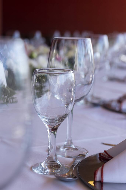 Un enfoque selectivo de dos vasos vacíos de diferentes tamaños en la mesa del evento
 - Foto, Imagen