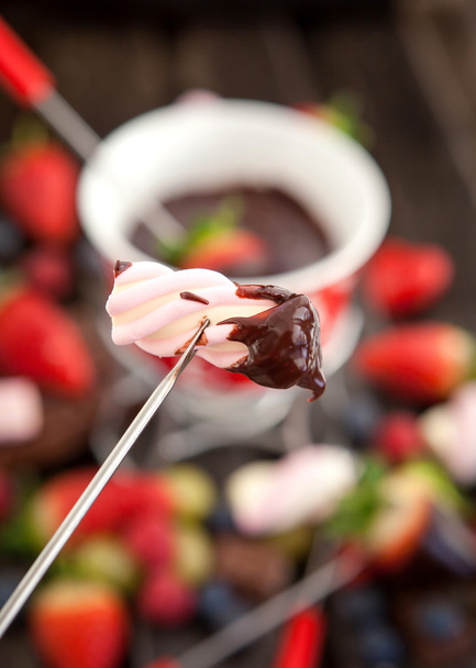 Marshmallow mergulhado em fondue de chocolate
 - Foto, Imagem