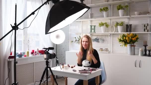 Beauty blogger woman filming daily make-up routine tutorial on camera. Influencer blonde girl live streaming eyelashes mascasra review in home studio with professional lighting equipment. Vlogger job. - Video