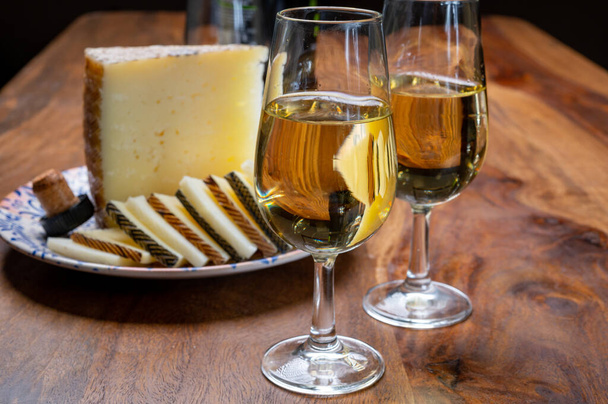 Španělské fino suché sherry víno z Andalusie a kousky různých ovčích tvrdých manchegových sýrů z La Mancha ve Španělsku. Párování vína a sýra - Fotografie, Obrázek