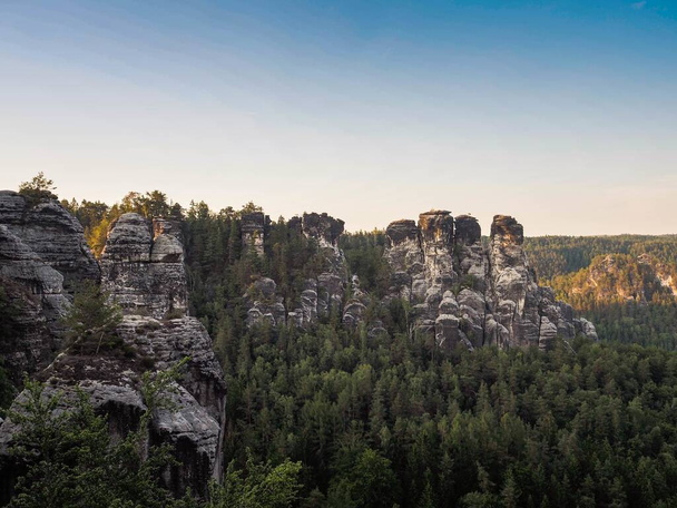 高山の木々に囲まれた山の岩の列の美しいショット - 写真・画像