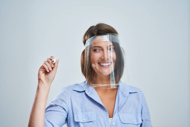 Attraktive Frau trägt Schutzschild Schrift über weißem Hintergrund - Foto, Bild