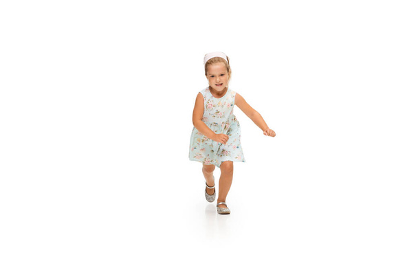 Happy little caucasian girl jumping and running isolated on white background - Foto, Imagem