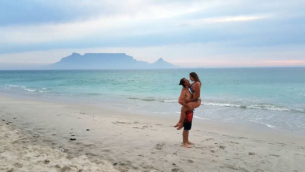 Młoda para spacerująca po plażach Kapsztadu: Bloubergstrand i widok z Góry Stołowej - Zdjęcie, obraz