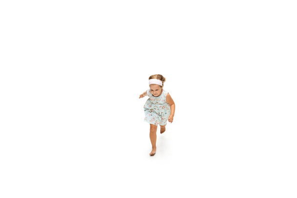 Happy little caucasian girl jumping and running isolated on white background - Фото, зображення