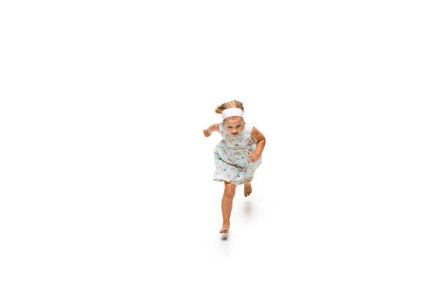 Happy little caucasian girl jumping and running isolated on white background - Foto, immagini