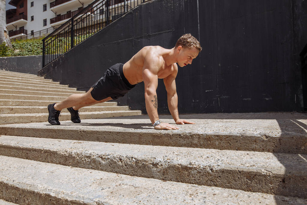 Deportista entrenamiento push up ejercicio al aire libre en la escalera - Foto, Imagen