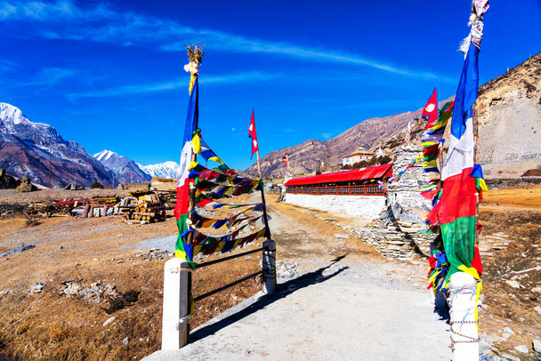 Панорамний вид на популярну туристичну стежку в Непалі - Аннапурна траса. Шлях до базового табору і Торонг Ла або Торунг Ла-Пасс. Погляньте на барвисті прапори буддистів, що пурхають на вітрі.. - Фото, зображення