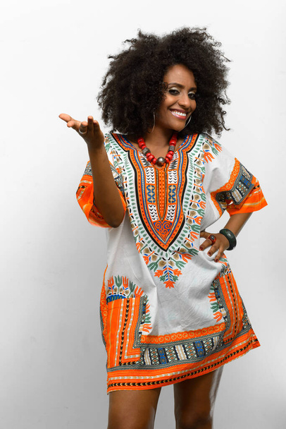 Studio zdjęcie młodej pięknej afrykańskiej kobiety z afro włosy noszenie tradycyjnych ubrań na białym tle - Zdjęcie, obraz
