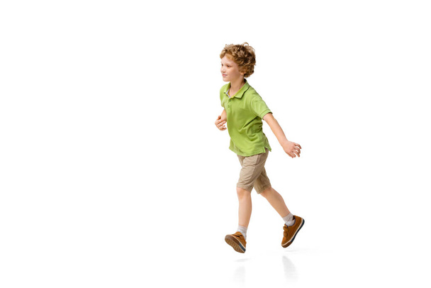 Happy little caucasian boy jumping and running isolated on white background - Fotoğraf, Görsel