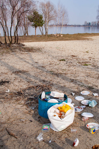 Homokos strand tele szeméttel és üres üvegekkel. - Fotó, kép