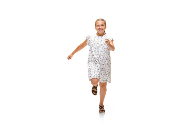 Glückliche kleine kaukasische Mädchen springen und laufen isoliert auf weißem Hintergrund - Foto, Bild