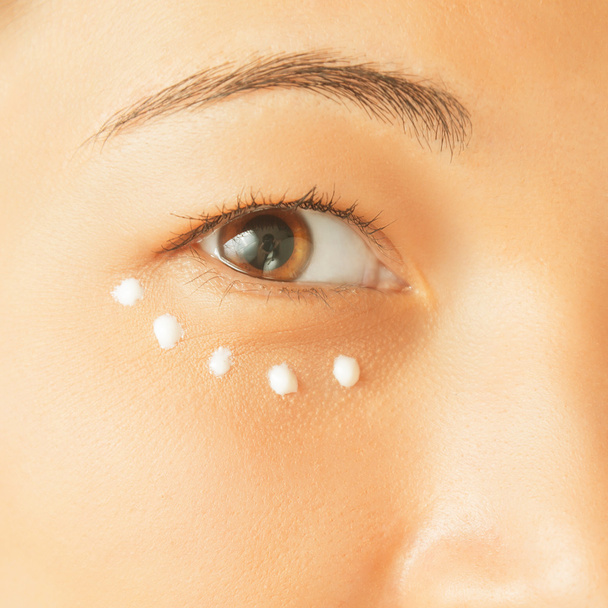 Applying cream for skin around eye - Foto, imagen