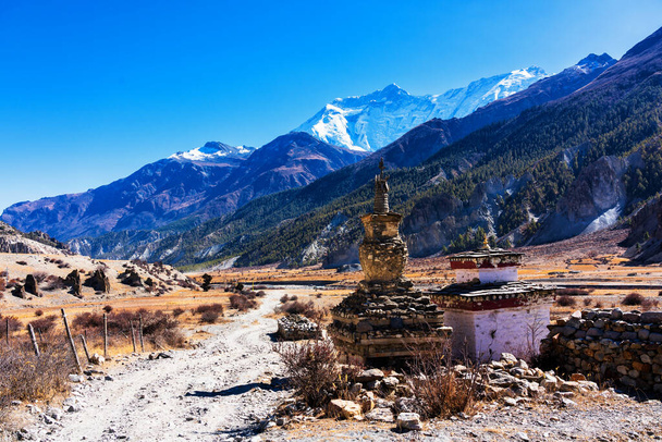 Stupa bouddhiste sur un sentier de randonnée autour du massif de l'Annapurna. Destination touristique populaire célèbre Annapurna Circle Trail, Népal - Photo, image