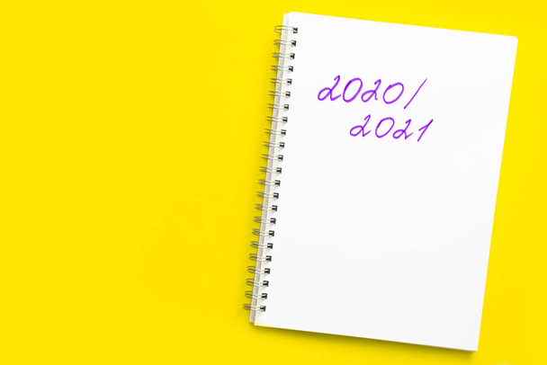 Inscription 2020 - 2021 v bílém notebooku se spirálou, na žlutém pozadí.  - Fotografie, Obrázek