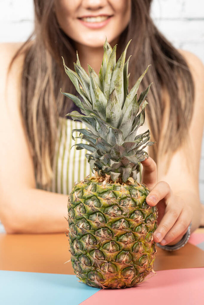 Femme mettant un ananas sur la table - Photo, image