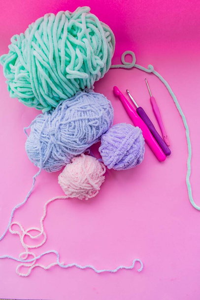 Fils roses pour tricoter, aiguilles à tricoter et crochets. Fond rose. Concept de travail à l'aiguille. - Photo, image