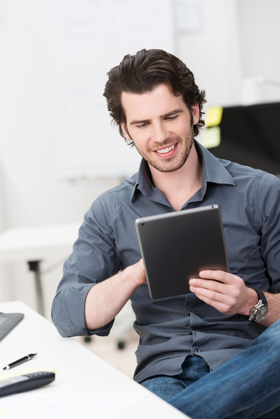 Happy businessman reading his tablet screen - Zdjęcie, obraz