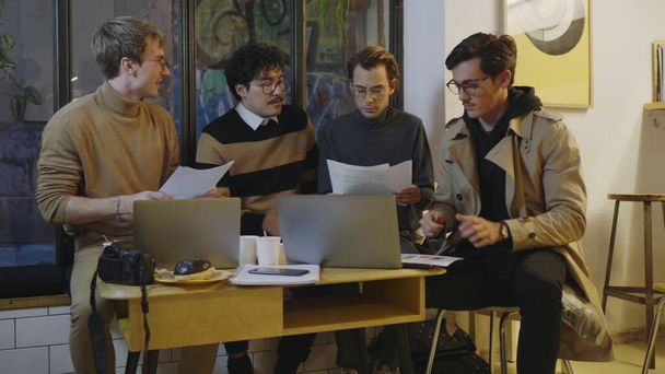Des hommes d'affaires lisant des documents dans un café. Partenaires masculins discutant de documents d'affaires - Photo, image