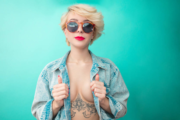Sexual woman in denim jacket with tattoo under breast. Rock Star - Fotó, kép