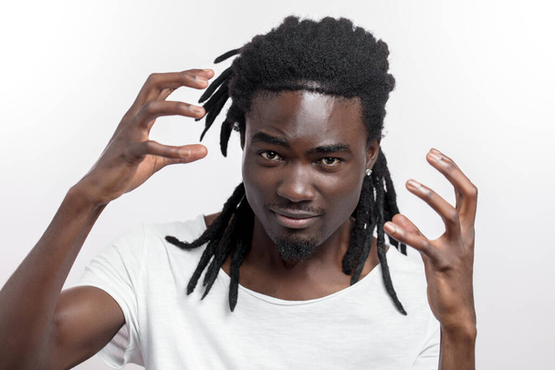 emotional young african man with dreadlocks standing isolated over white. Looking camera. - Foto, Imagem