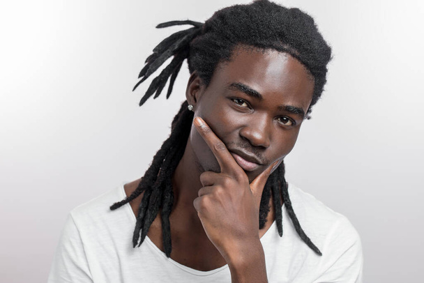 serious dark skinned male, has pensive expression, isolated white background. African American man thinks - Fotó, kép