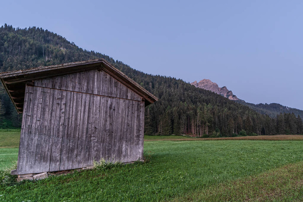 cobertizo de madera inmerso en el paisaje montañoso de la Val Pusteria en los Dolomitas del Tirol del Sur
 - Foto, Imagen