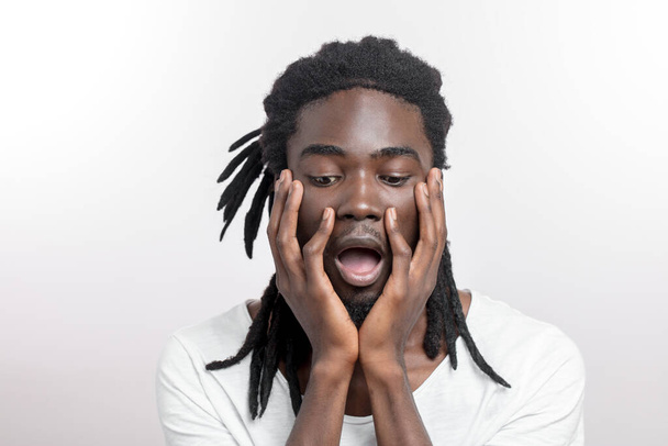 shocked African American man wearing white T-shirt looking at camera in surprise - Valokuva, kuva