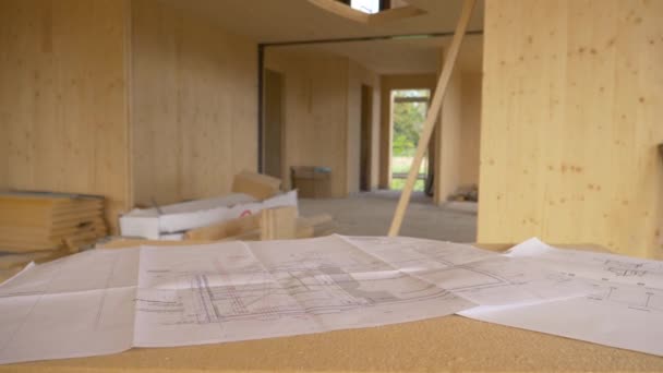 CLOSE UP: Blueprints and other plans lie on a makeshift desk in a CLT house. - Footage, Video